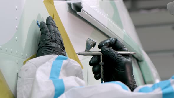 Slow Motion Painter Paints Body of Helicopter with Precision Spray Gun alt