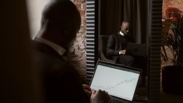 Black Businessman Using Laptop for Analyzing Data Stock Market Stock Exchange Trading Online alt