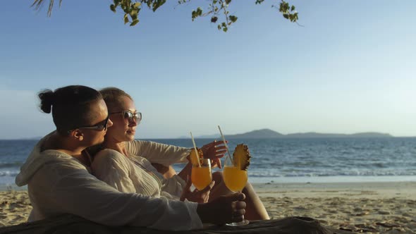 Loving Couple in White Dress Sunglasses in Hugging Relax and Drinking Cocktail alt