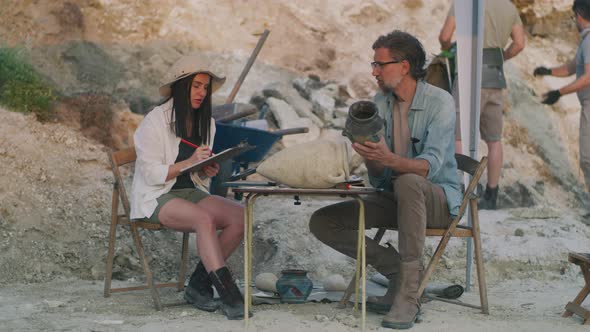 Archaeologists Analyzing Old Vessel Together alt