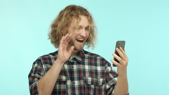 Slow Motion of Attractive European Man with Blond Long Hair and Beard Having a Call on Smartphone