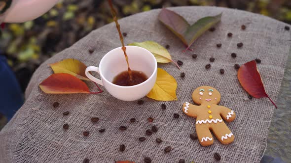 Gingerbread Man and Cup of Coffee Near Autumn Leaves alt