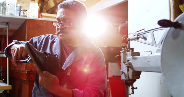 Shoemaker repairing a shoe alt