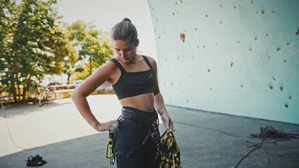 Young Woman Hanging Carbines on Her Belaying Harness Outdoors Tracking Shot alt