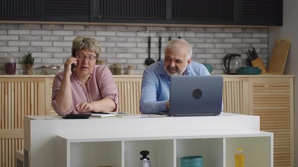 Aged Housewife is Calling to Utility Company and Consulting About Payment Elderly Man is Sitting alt