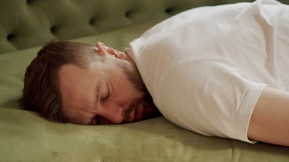 Middle Plan a Man Falls on the Sofa From Fatigue Face Down and Immediately Falls Asleep alt