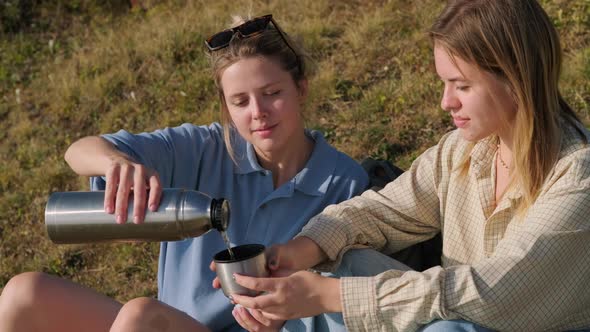 Friends Relaxing and Having Tea After a Long Walk in the Countryside alt