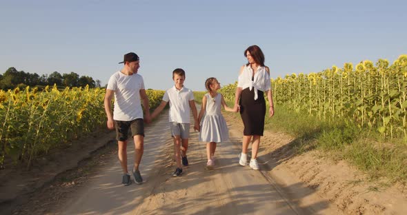 A Happy Family With Two Children Is Walking In Nature