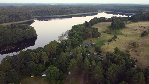 Unbelievable aerial flight rising up drone shot overview lake in summer morningin nature reserve Mü alt