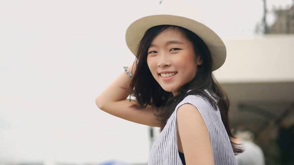 Happy young Asian woman smiling looking at the camera.