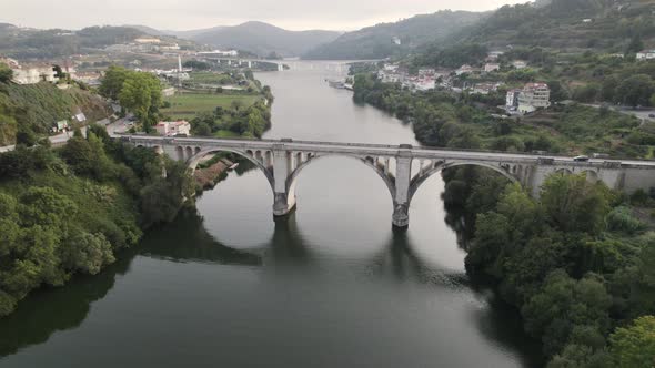 Aerial slowly descending, Beautiful Entre-os-Rios Arched bridge Tâmega river, Portugal