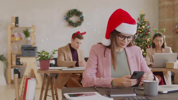 Portrait of Cheerful Businesswoman in Santa Hat alt