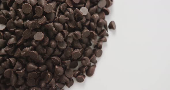 Video of close up of multiple chocolate chip over white background alt