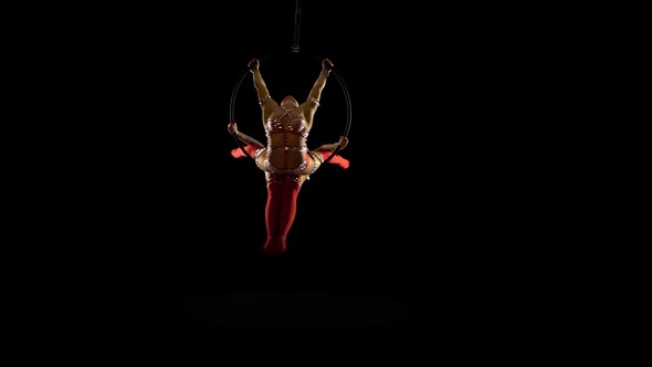 Two Gymnasts Performs a Trick on the Aerial Hoop. Black Background alt