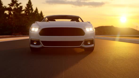 White Sports Car Shooting From Front While Driving On Asphalt Road At Sunset