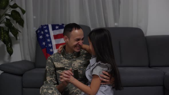 Happy Little Girl Daughter with American Flag Hugging Father in Military Uniform Came Back From US