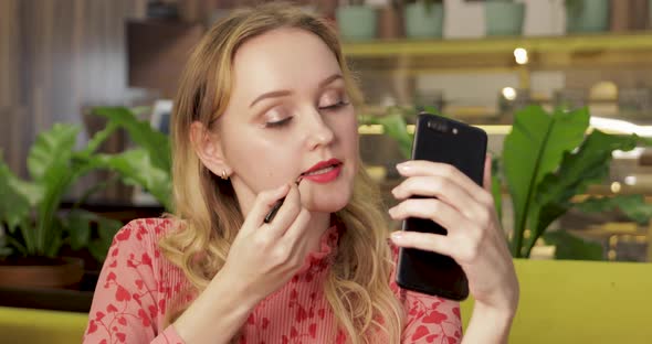 Romantic Style Young Blonde Woman Applying Pink Lipstick Using Phone Camera