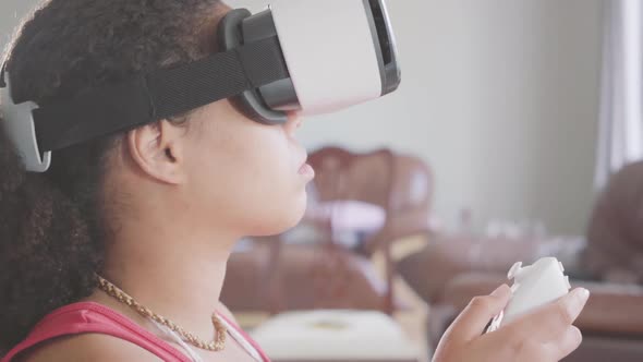 Portrait of African American Woman Wearing in the Virtual Reality Headset Using Joystick alt