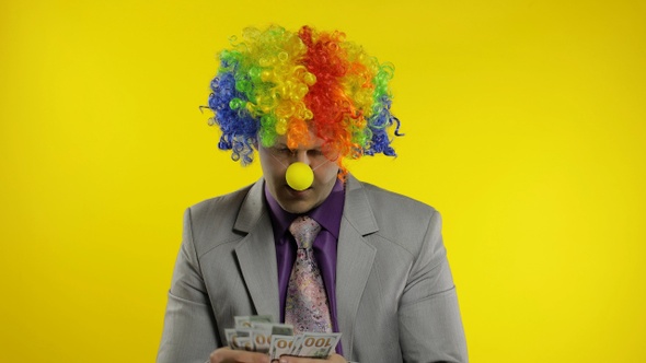 Clown Businessman Entrepreneur Counts Money Income. Hand Steals Cash From Man alt