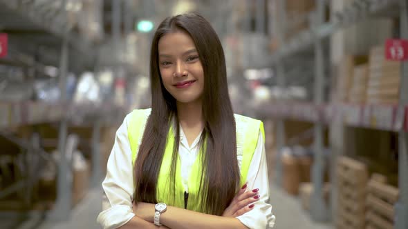 Portrait of the Beautiful Asian Female Worker Standing and Smiling Charmingly in storage warehouse. alt
