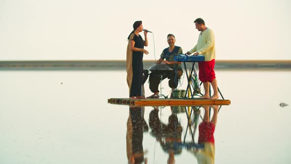 Woman Is Singing To the Music Played By Men with Piano and Hang Drum, Raft,  alt