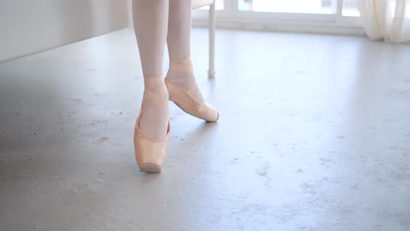 Close up legs and ballet shoes from girl practice the dancing and use bed to support the training