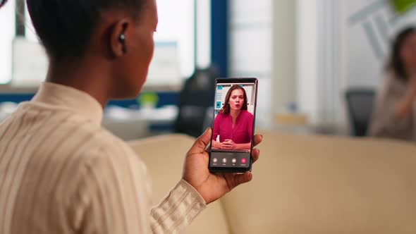 Back View of African Woman Discussing with Remote Manager on Video Call alt