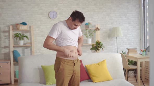 Young Man Looking in the Mirror Finds Himself at the Waist Folds alt