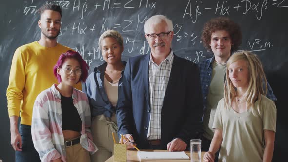 Cheerful Senior Professor and Multiethnic Students Posing Together for Camera alt