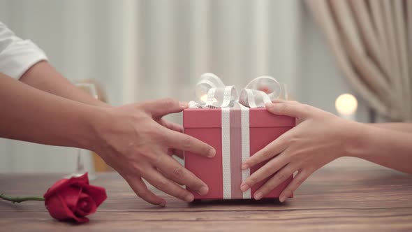 Close up man give the gift box to his girlfriend