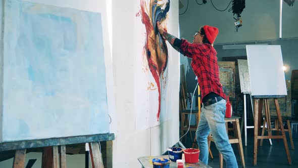 A Man is Painting a Huge Flower with Bare Hands alt