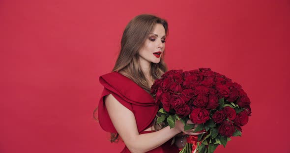 Brunette Girl with Long Hair in Red Blouse Turning Flowers