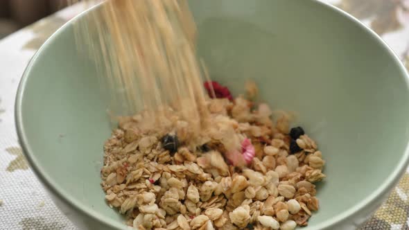 A Man Pours Breakfast Cereals From a Bag Into a Plate in the Morning Closeup alt