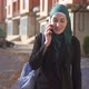 Muslim Woman in Hijab Walking and Talking on the Phone in the Cityslow Mo