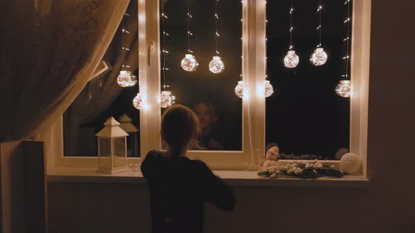 Girl Comes to the Window with Garlands alt