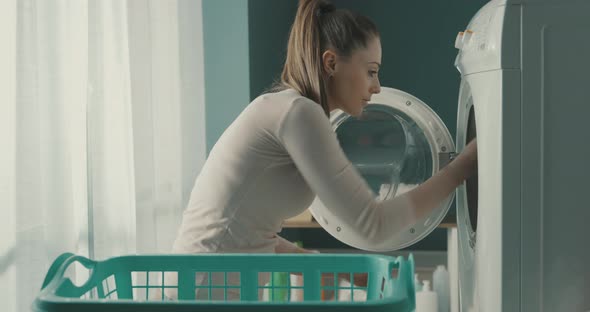 Woman removing clean laundry from the washing machine