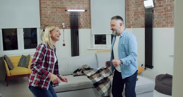 Couple which Having Fun Together when Dancing Twist in Living-Room alt