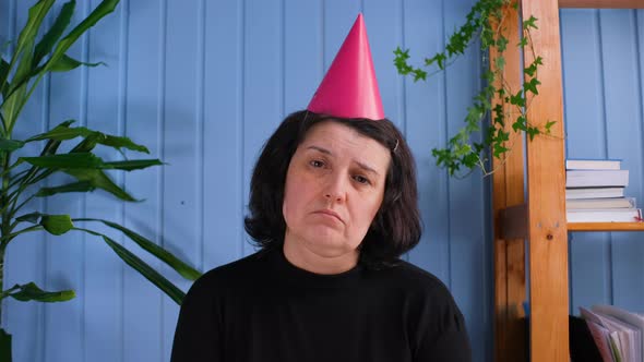 Sad Old Woman Whit Bitrthday Hat and Looking with Sad Eyes on Camera