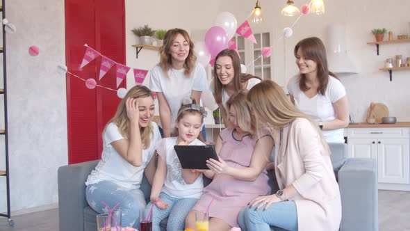 Women Looking at Tablet at Baby Shower Party