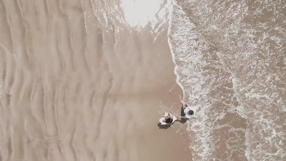 Birdseye View Of Couple Walking On The Sand Beach alt