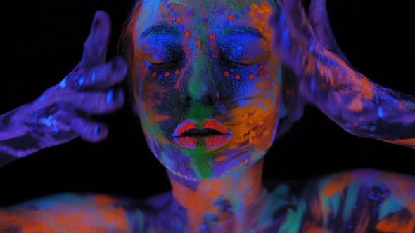 A Magical Space Girl with UV Drawings on Her Face and Body in the Dark alt