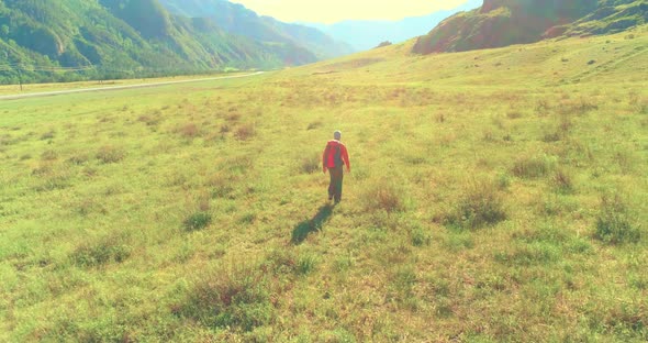Flight Over Backpack Hiking Tourist Walking Across Green Mountain Field alt