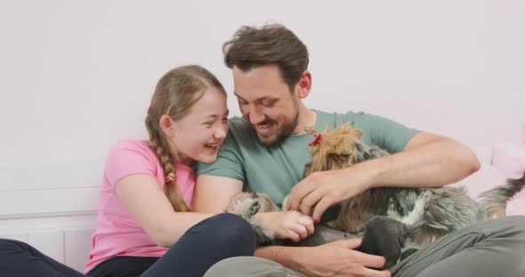 Father and Teen Daughter are Sitting on the Sofa and Laughing Happily Play with Two alt
