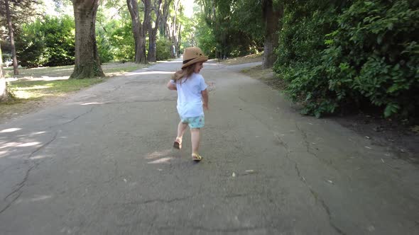 Little girl running outside in the park. Playing chase with his father. Catch Me If You Can. alt