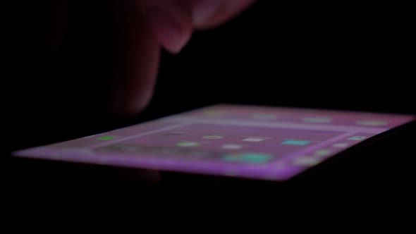Scrolling through smart phone menu pages in dark 4K 3840X2160 UHD video - Using smart phone display  alt