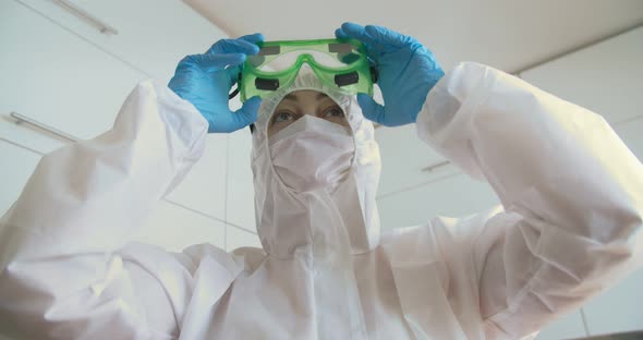 A doctor in protective clothing, a mask and goggles, close-up. Tired look. Antivirus suit