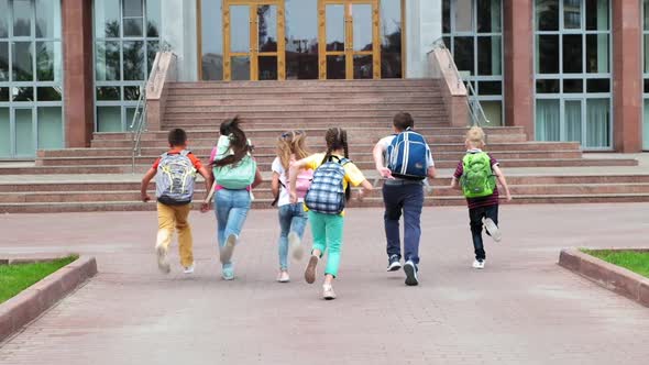 Junior Students with Schoolbags Walk To School Building alt
