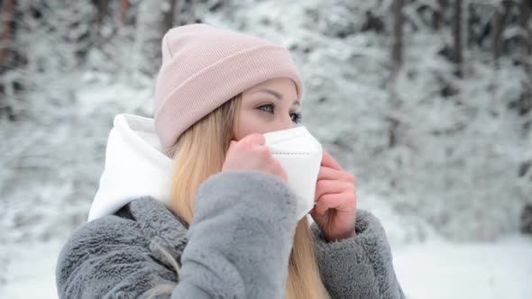 Beautiful Girl Portrait in Profile in the Winter Forest Wears a White Protective Mask Against the alt