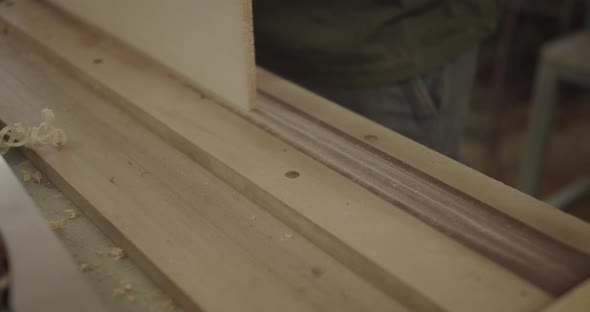 Carpenter filing plank of wood