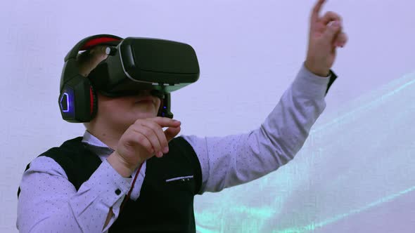 A Boy in Augmented Reality Glasses Presses Virtual Buttons with His Fingers alt